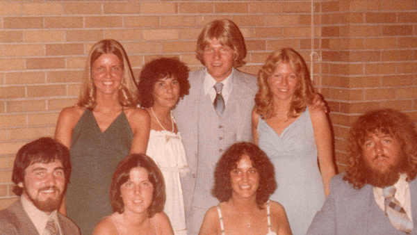 8 people dressed up smile for a photo at a wedding