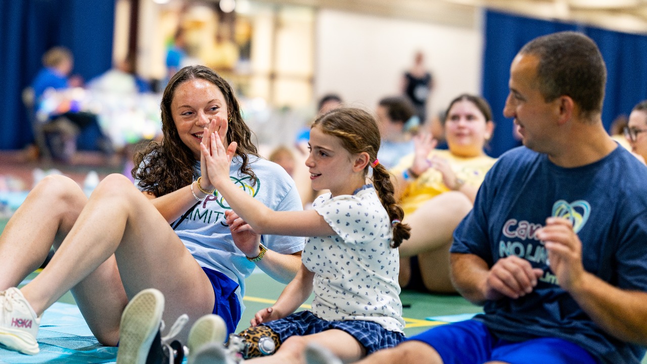 Camper and Sarah Springer '26, OTD '28, exchange high five during Camp No Limits
