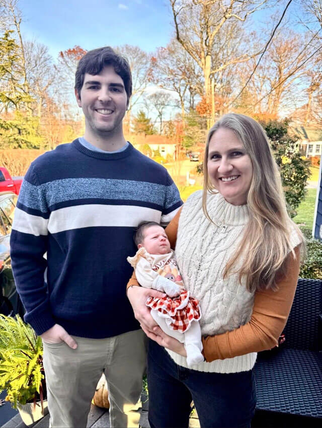 Alex and Eileen Bernstein smile together with their newborn baby