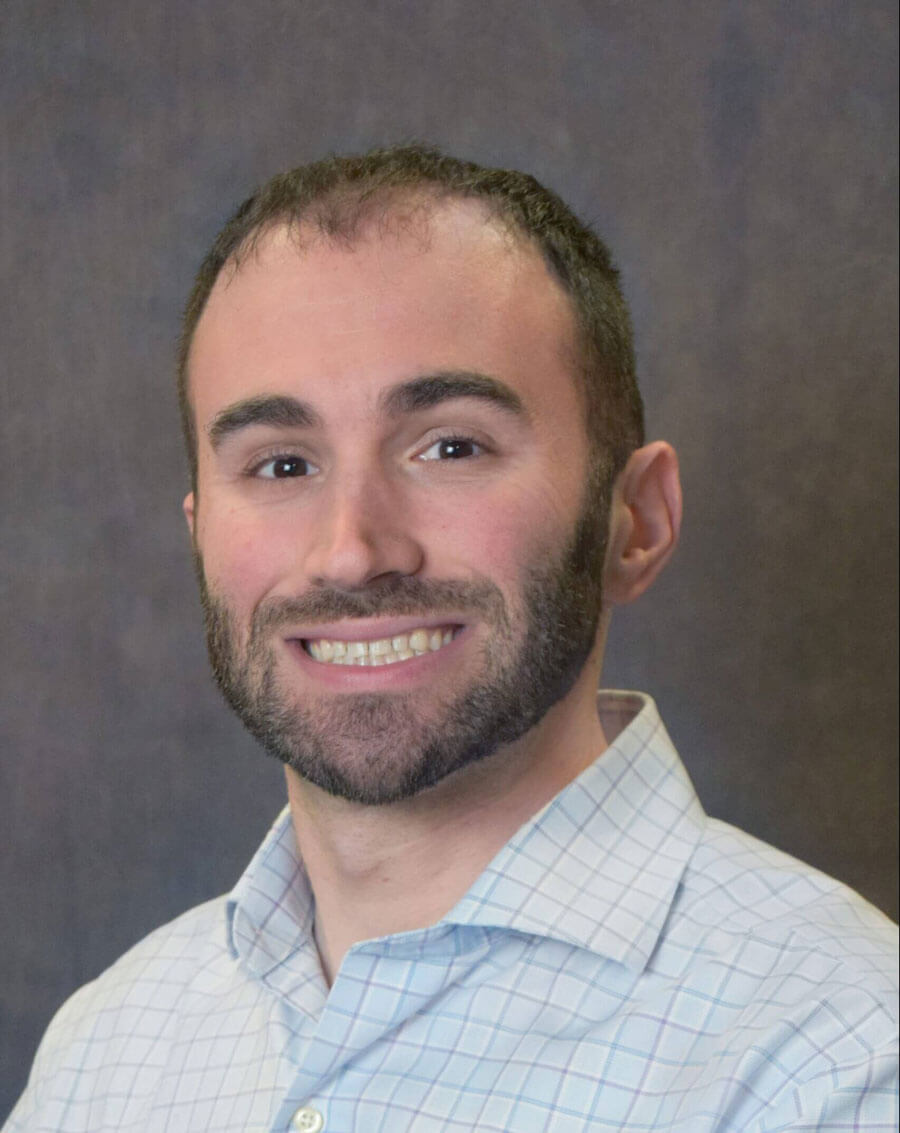 person smiling looking at camera wearing a button down shirt