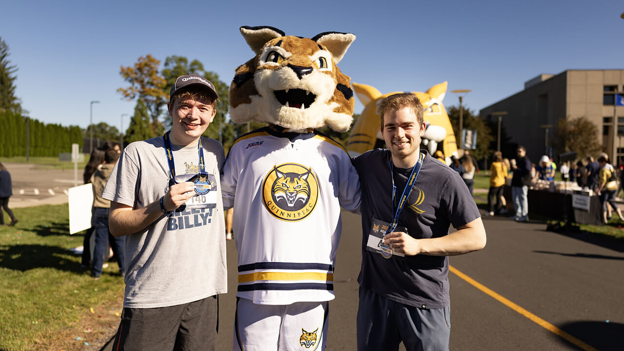 Two runners posing with Boomer.