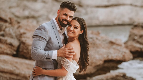 Alex Rigazio and Alexis (Smith) Rigazio pose cheek to cheek on the beach on their wedding day