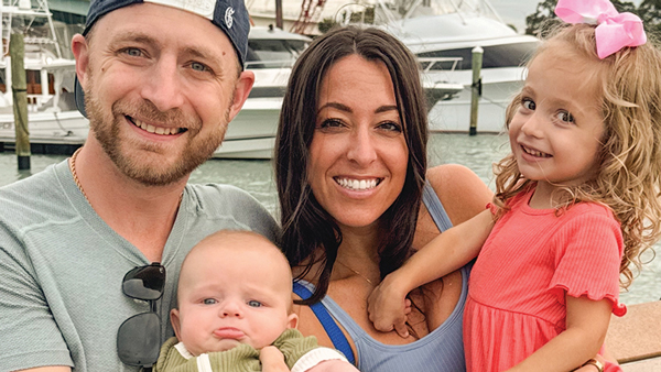 Larisa (Madison) Vivolo and Vincent Vivolo with their children smile for a photo on a boat dock