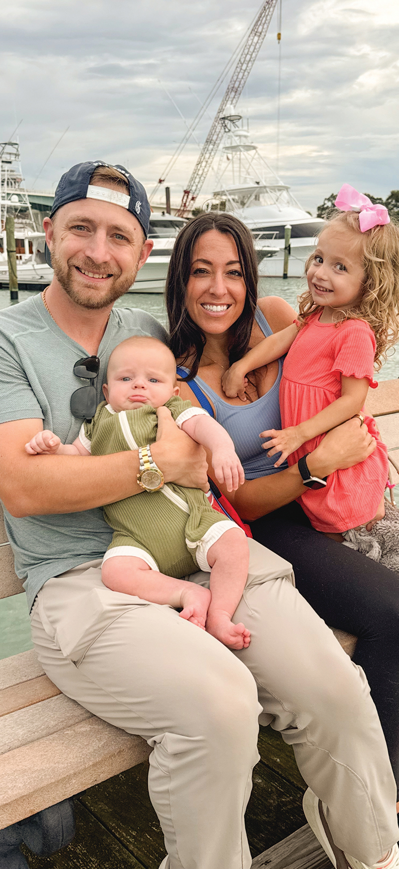 Larisa (Madison) Vivolo and Vincent Vivolo with their children smile for a photo on a boat dock