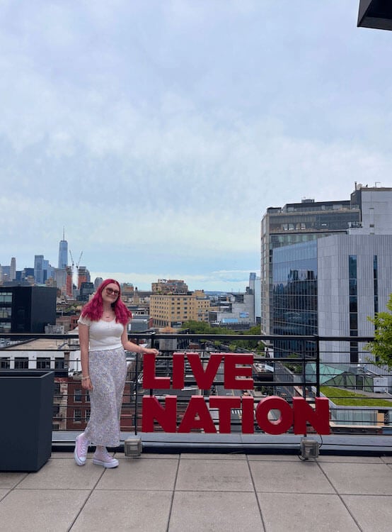 Jennifer Moglia poses on a rooftop next to a Live Nation sign